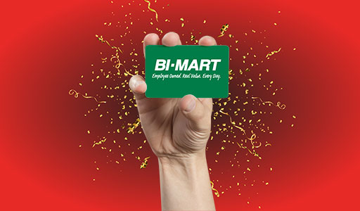 Bi-Mart card in hand with gold confetti background